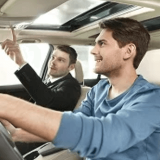 Man testing a new car with a dealer, representing audiences of car buyers and automotive enthusiasts interested in vehicles and mobility solutions.