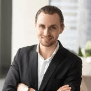 Confident entrepreneur in a business suit smiling at the office, representing audiences of professionals, executives, and startup founders.